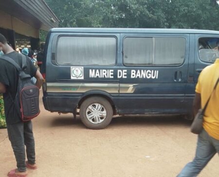 Devant la morgue de l’hôpital communautaire de Bangui, le seul corbillard de la mairie trône comme un symbole de racket institutionnalisé. Ce vieux véhicule bleu, marqué du logo municipal, est imposé à toutes les familles endeuillées, qu’elles aient besoin ou non de ses services. Pour récupérer un corps, chaque parent doit verser 15 000 francs CFA, une somme encaissée sans justificatif officiel. Même ceux qui habitent à quelques centaines de mètres et souhaitent transporter eux-mêmes leur défunt sont contraints de payer. Ce système, mis en place par les agents de la mairie et de la morgue, transforme chaque sortie de corps en une véritable taxe illégale, faisant du deuil des familles un marché lucratif.