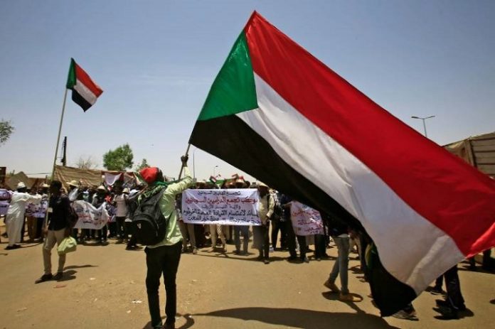 manifestants-soudanais-avec-un-drapeux-du-soudan Les alliés arabes du Soudan soutiennent les militaires au pouvoir