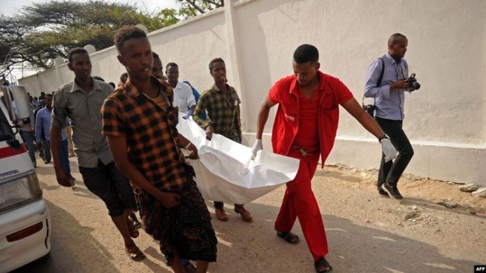 Quelques personnes portent le corps d'une victime de l'explosion de voiture près de l'hôtel Doorbin à Mogadiscio-le 24 février 2018 Quelques-personnes-portent-le-corps-dune-victime-de-lexplosion-de-voiture-près-de-lhôtel-Doorbin-à-Mogadiscio-le-24-février-2018 Six morts dans l'attentat contre la mairie de Mogadiscio en Somalie