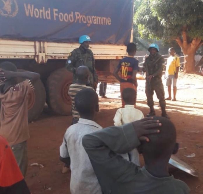 un camion du programme alimentaire à Bria en République centrafricaine des-enfants-observent-un-camion-du-PAM-sécurisé-par-les-soldats-de-la-Minusca-dans-une-rue-de-Bria Centrafrique : 63% de la population en besoin d'assistance humanitaire, selon l'ONU