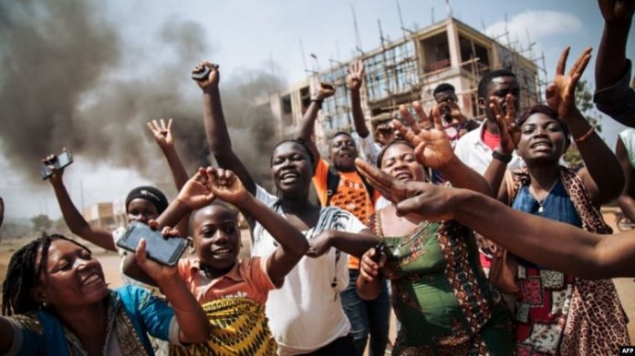 Les manifestants crient à côté d'un barrage routier au milieu de l'avenue principale de Beni lors d'une manifestation contre le report des élections sur le territoire des Beni et de la ville de Butembo le 27 décembre 2018. Trois-personnes-tuées-par-balles-dans-une-manifestation-dans-l’Est Trois personnes tuées par balles dans une manifestation à l’Est de RDC.