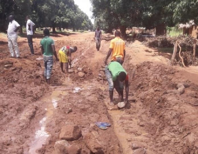 colmatage de route par les populations villageoise, illustrant l'article sur Sangha-Mbaéré : Les jeunes de Koundapaye restaurent leur route