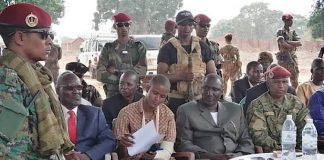 Le chef rebelle Ali Darassa, en costume marron français, entouré à sa gauche de son porte-parole, et à sa droite de l’un des officiers de la Seleka, lors de la signature de l’accord de paix intergroupe armé à Bria, le 19 mars 2020. Photo CNC/ Moïse Banafio