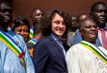 Dmitry Sitiy (au centre), fondateur de la société minière Lobaye Invest et placé sous sanctions du Trésor américain pour ses liens présumés avec le groupe Wagner, entouré de députés centrafricains sur les marches de l'Assemblée nationale à Bangui le 15 octobre 2021. - AFP