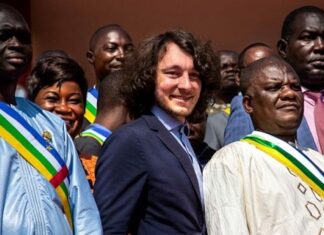 Dmitry Sitiy (au centre), fondateur de la société minière Lobaye Invest et placé sous sanctions du Trésor américain pour ses liens présumés avec le groupe Wagner, entouré de députés centrafricains sur les marches de l'Assemblée nationale à Bangui le 15 octobre 2021. - AFP