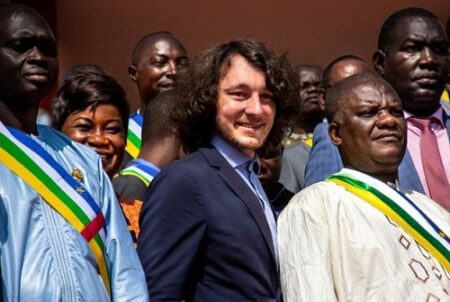 Dimitry Sytii (au centre), fondateur de la société minière Lobaye Invest et placé sous sanctions du Trésor américain pour ses liens présumés avec le groupe Wagner, entouré de députés centrafricains sur les marches de l'Assemblée nationale à Bangui le 15 octobre 2021. - AFP