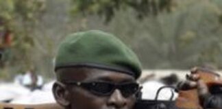 un beret vert de la garde présidentielle qui porte une lunette noire