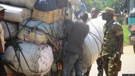 Un gendarme centrafricain prospectant des bagages à un barrage routier, en novembre 2017. , VOA, Freeman Sipila  