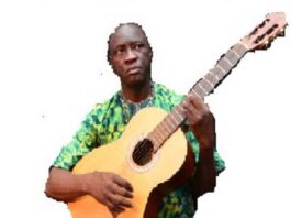Monsieur Gervais Lakosso avec une guitard à la main en train de chanter