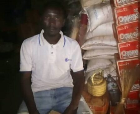 Un commerçant boutiquier du marché central de M'Boki où l'on voit les boîtes de sardines et des sacs du sel. CopyrightCNC