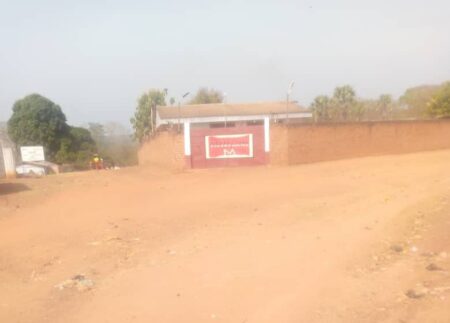 Siège local de l'ONG The MENTOR Initiative Alindao dans une zone de poussière