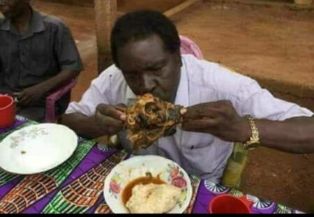 Fidèle Gouandjika, ministre conseiller à la présidence et triple champion en titre de la gastronomie en Centrafrique mangeant sa tête de chèvre. 