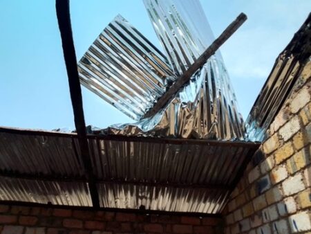 Conséquences d’une tornade à Kouango avec un toit en tôle endommagé et ciel bleu en fond.”