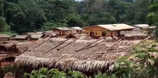 Vue d’une localité tropicale de Gnanti, dans la commune de Bilolo, avec des toitures de chaume et un bâtiment intitulé “DYNAMES DE YANTE”, nichée dans une vallée verdoyante