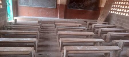 Salle de classe vide avec des bancs en bois traditionnels à l’école Galabadja, Bangui