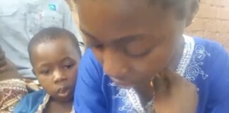 Jeune fille en larmes tenant son petit frère, lisant une lettre de licenciement, en appelle à l’aide auprès du président et du ministre de la jeunesse en Centrafrique.