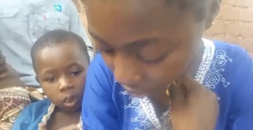 Jeune fille en larmes tenant son petit frère, lisant une lettre de licenciement, en appelle à l’aide auprès du président et du ministre de la jeunesse en Centrafrique.