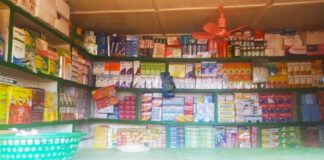 Étagères bien garnies avec des produits de santé et de parapharmacie dans une pharmacie.
