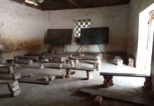 Photo montrant l’intérieur d’une salle de classe délabrée à Yalinga avec des bancs en bois et un tableau noir.