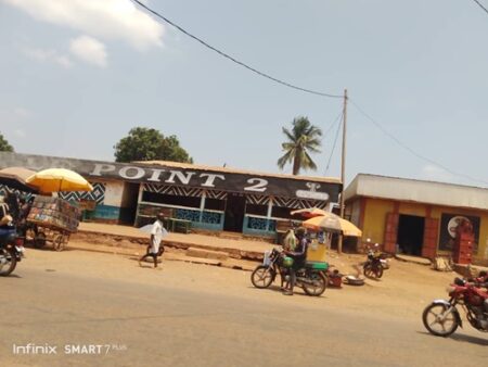 Des motos et des vendeurs ambulants devant le magasin Point 2 au marché Gobongo, à la sortie nord de Bangui.