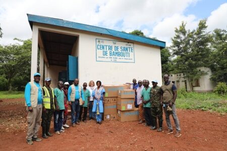 Équipe de l’UNICEF et personnel local devant le Centre de Santé de Bambouti avec des cartons de médicaments.