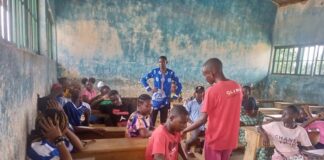 Élèves de Kaga Bandoro assis sur des tables-bancs récemment fournies par l’ONG Jeunesse en Mission dans une salle de classe en mauvais état
