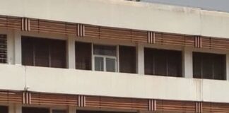 Entrée principale de l’hôpital de l’Amitié à Bangui, avec des patients et des visiteurs devant le bâtiment.
