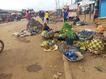 Rue principale de Kilomètre 5 à Bangui avec des piles de déchets tout le long.