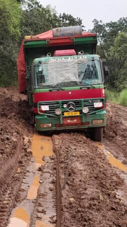 Camion embourbé sur une route boueuse et dégradée en direction de Paoua, montrant l'état désastreux des infrastructures routières pendant la saison des pluies.