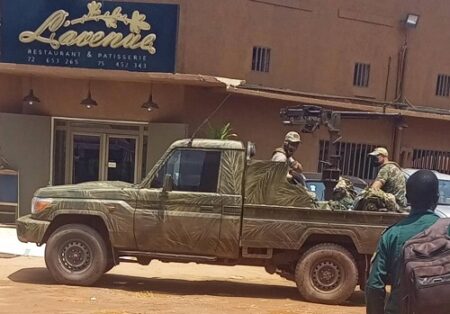 Mercenaires du groupe Wagner en tenue de camouflage à bord d’un pick-up armé stationné devant un bâtiment à Bangui