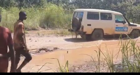 Véhicule de l’UNICEF traversant une route boueuse et inondée à 103 km de Batangafo , en route pour la distribution de kits scolaires à Batangafo .