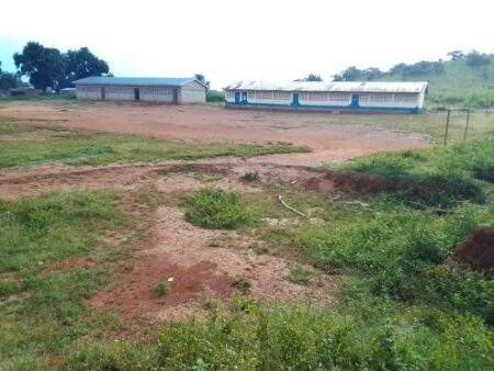 Vue du terrain de l’École mixte de Koundé montrant deux bâtiments en arrière-plan, illustrant l'article sur 'École de Koundé : Un directeur sans logement, des salles vides, une rentrée fantôme