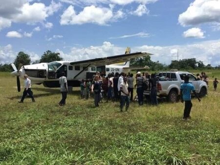 L’image montre un petit avion de type turbopropulseur stationné sur une piste herbeuse du parc de Dsanga Zanga, , probablement dans une zone rurale ou un aérodrome non pavé. L’avion porte l’immatriculation ZS-DRK sur le côté de sa queue, ce qui suggère qu’il s’agit d’un appareil i