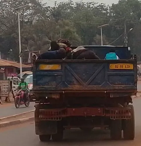 Camion chargé en mouvement des aliments congelés (poulets de chair, viande de porc, poisson) pour la poubelle derrière Boy-rabe que les jeunes se servent.